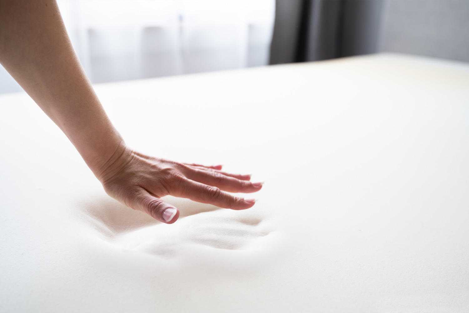 Рука залишає відбиток на піні Memory Foam, який повільно зникає